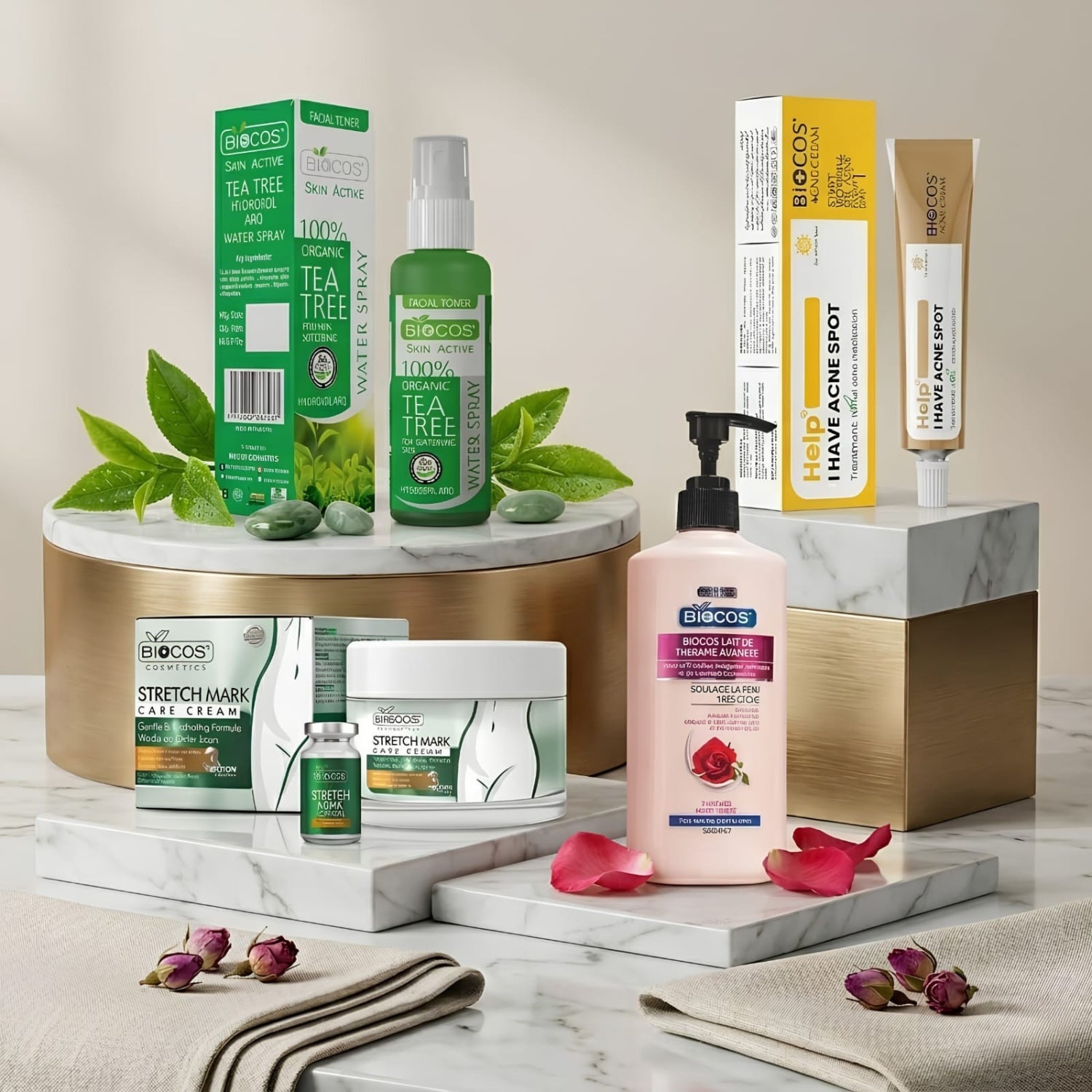 A styled product display of multiple skincare items from the brand Eudocos, including Stretch Mask Care Steam, Stretch Mask Care Cream, Hand Acne Shot, and Hair Growth Serum, arranged on white marble blocks and a gold cylindrical pedestal with green tea tree leaves and rose petals.