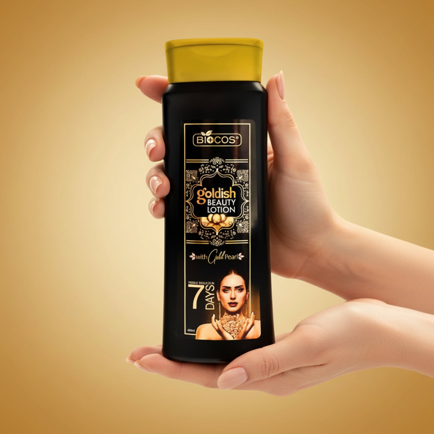 A person's hands holding a bottle of Biocos Goldish Beauty Lotion against a warm golden-brown gradient background.