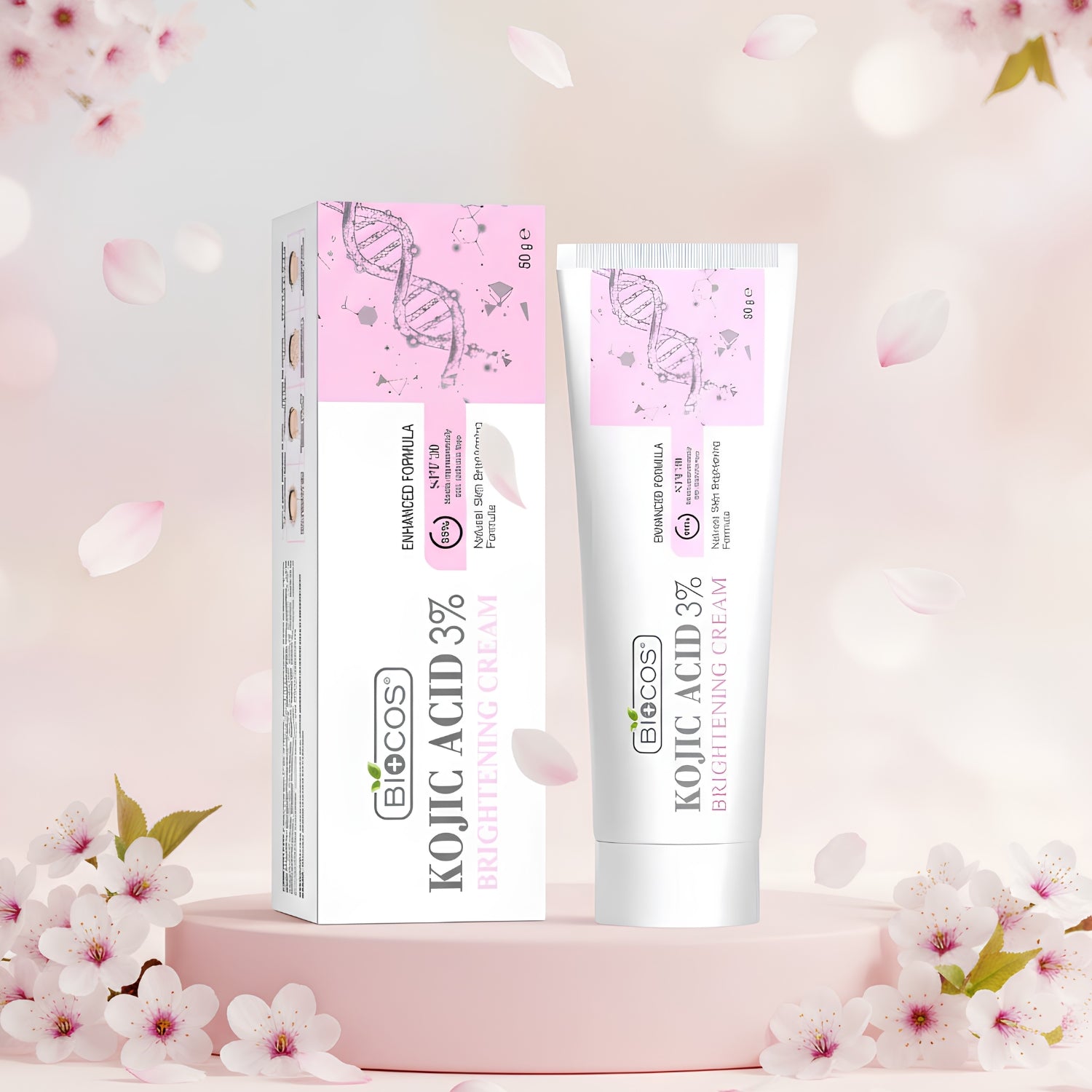 BioCos Kojic Acid 3% Brightening Cream shown in a white squeeze tube next to its pink and white packaging box, set on a pink pedestal with soft cherry blossoms.